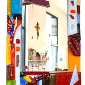 Unser rechteckiger Spiegel mit Glasrahmen im Design 'Bunt' ist ein lebendiges Unikat, das deinem Zuhause eine stilvolle und farbenfrohe Atmosphäre verleiht. Der rechteckige Glasrahmen besteht aus geschmolzenen bunten Opal- und transparenten Glasnuggets, die ein faszinierendes Muster erzeugen.